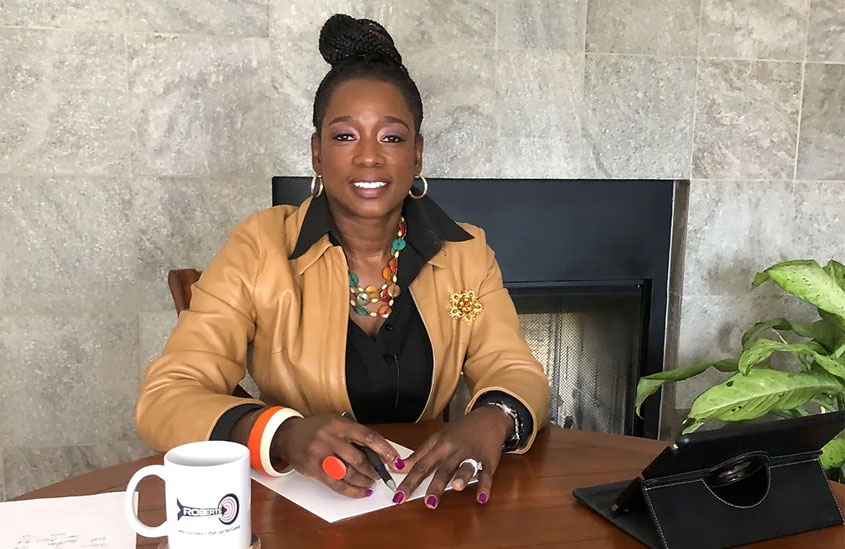 Paula Shipman-Roberts, CRNA, MNA (Coach, Author, and Speaker of Roberts Target Financials) sitting at her desk